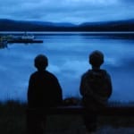 two kids in front of the lake at twilight two kids in front of the lake at twilight