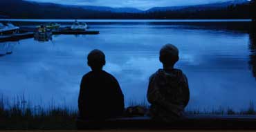 two young people looking at lake two young people looking at lake